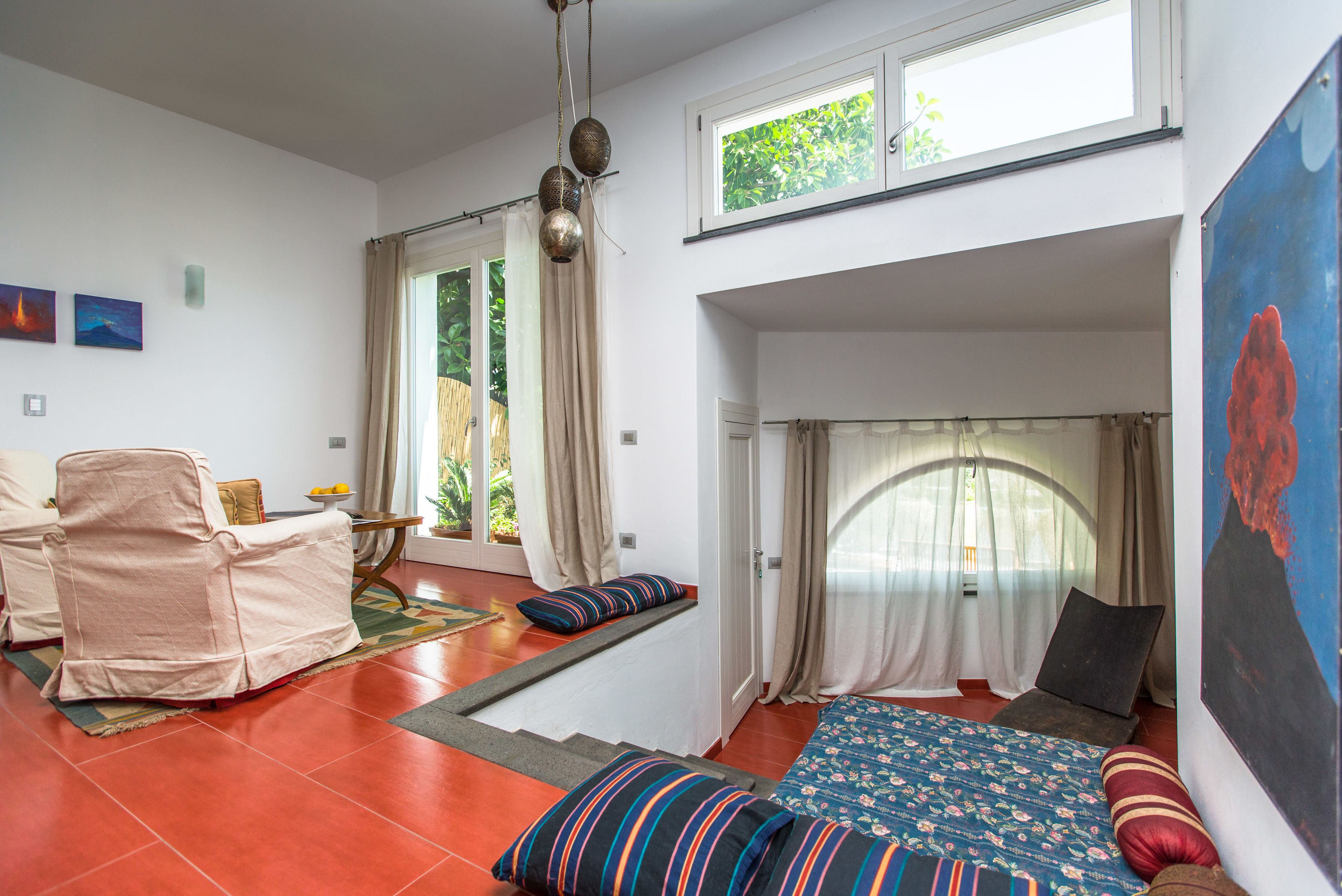 A room with a bed, a chair, a small table, and a window.