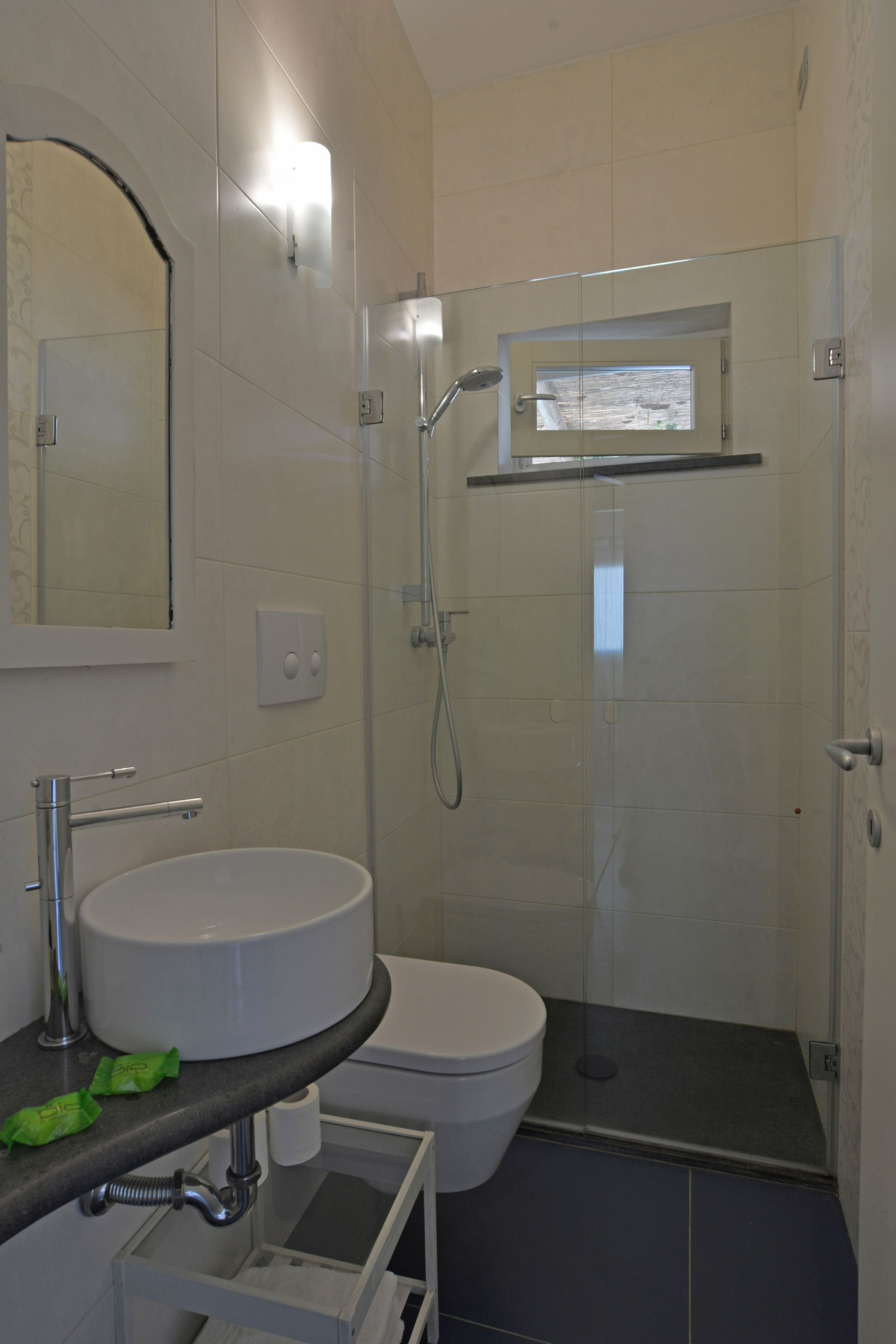 A bathroom with a sink, toilet, and shower enclosure.