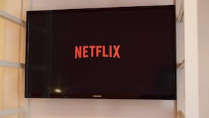A flat-screen TV mounted on a wall with the Netflix logo displayed. - Vanvitelli Domus (Naples)