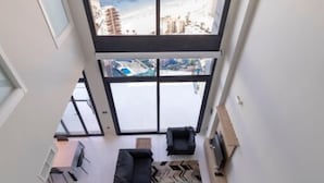 A modern living room with a large window overlooking a beach and ocean. - Sunset Drive Mar Holidays (Benidorm)
