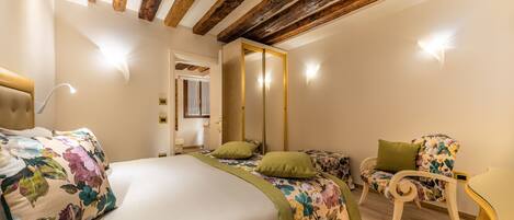 A bedroom with a bed, two bedside tables, a chair, and a mirror.