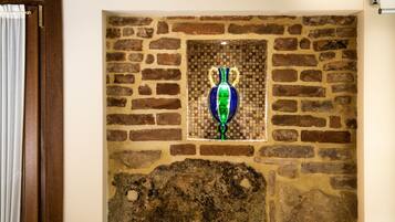 Un mur de briques agrémenté d’une fenêtre en mosaïque et d’une porte en bois.