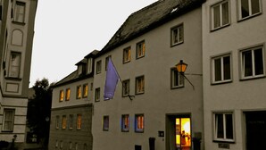 A building with multiple windows, some illuminated from inside. - Die Aussicht (Neuburg)