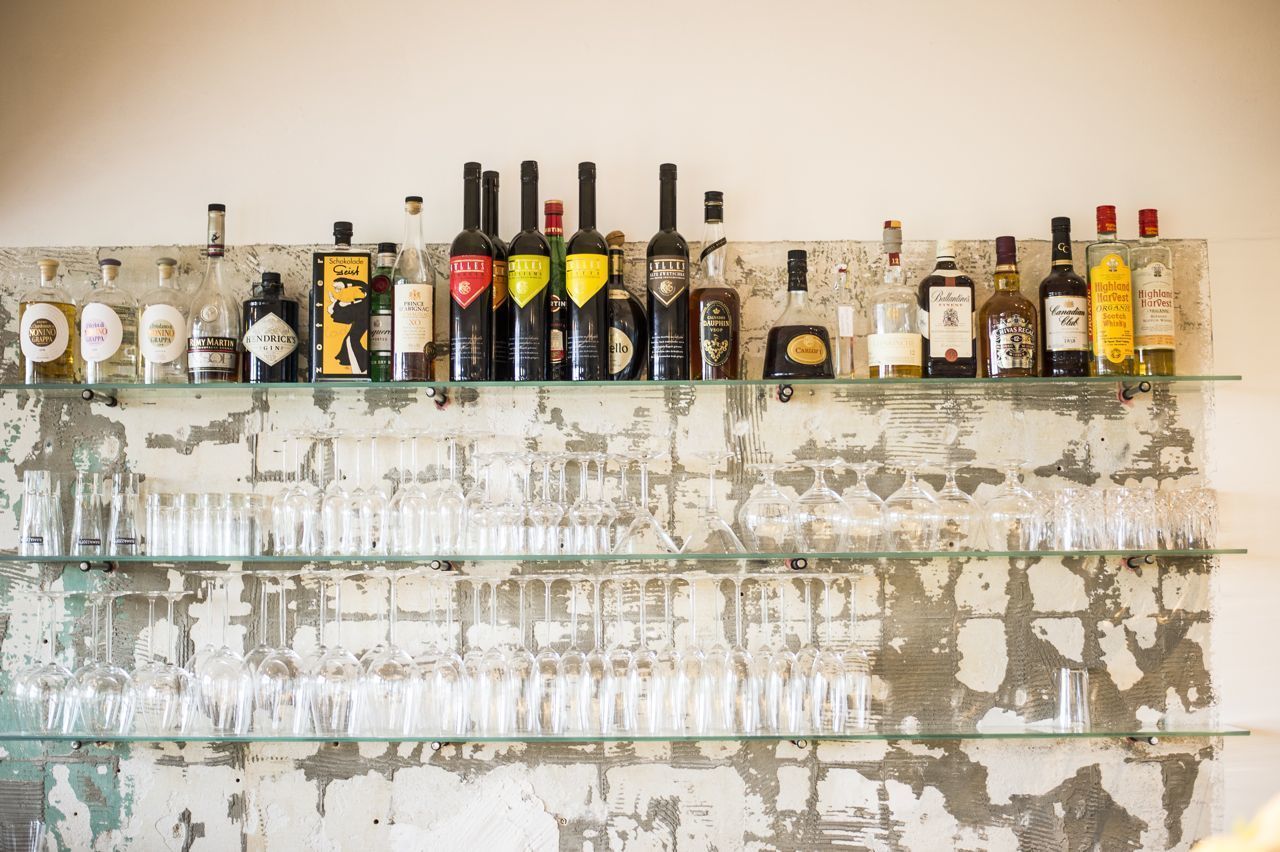 A bar with various bottles and glasses on shelves.