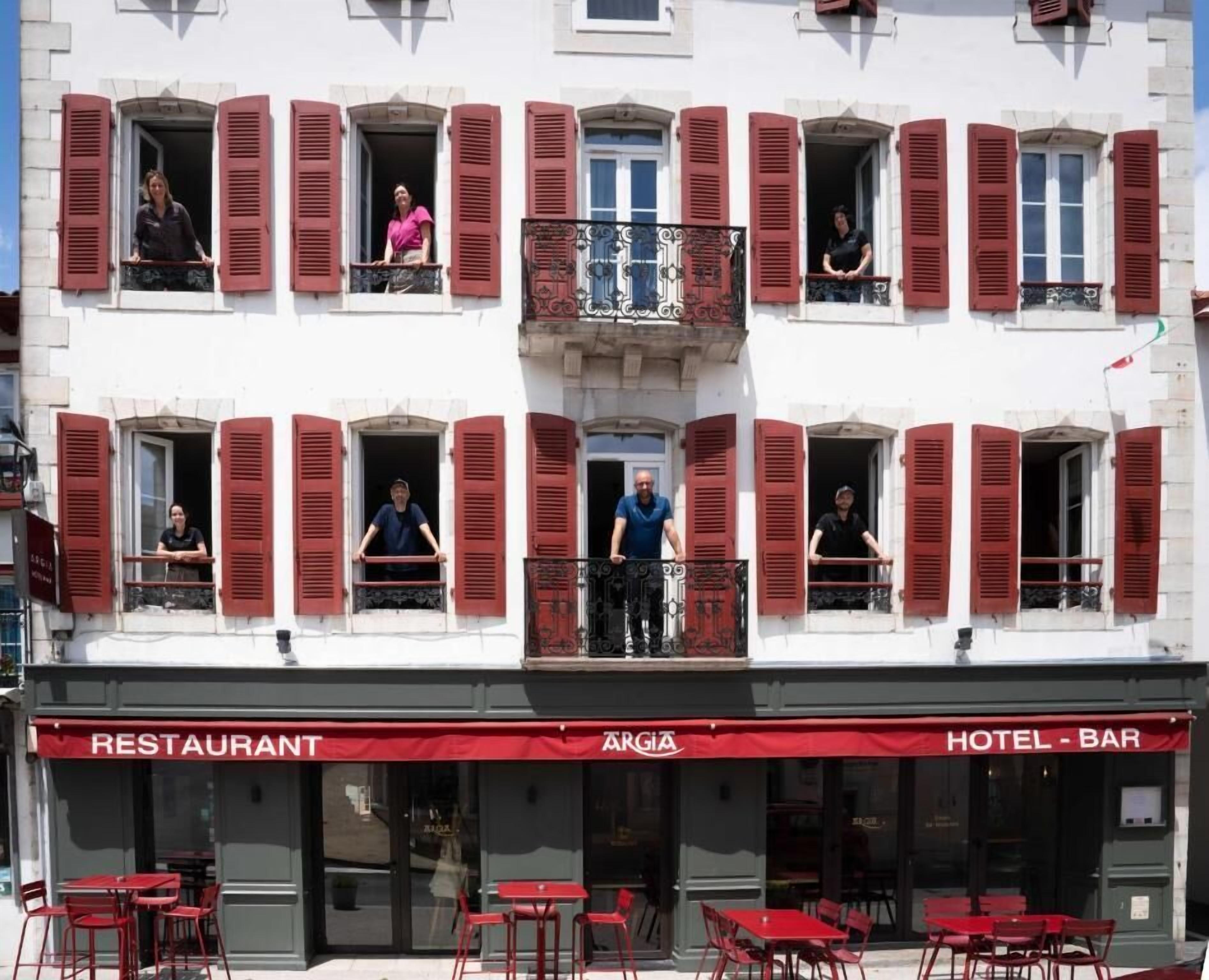 Ein Gebäude mit mehreren Balkonen, einem Restaurant und einer Hotelbar.