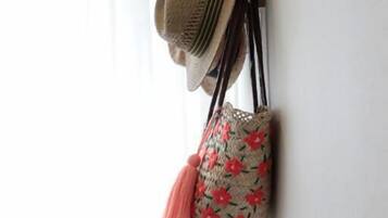 A wall-mounted shelf with a woven hat and a woven bag.