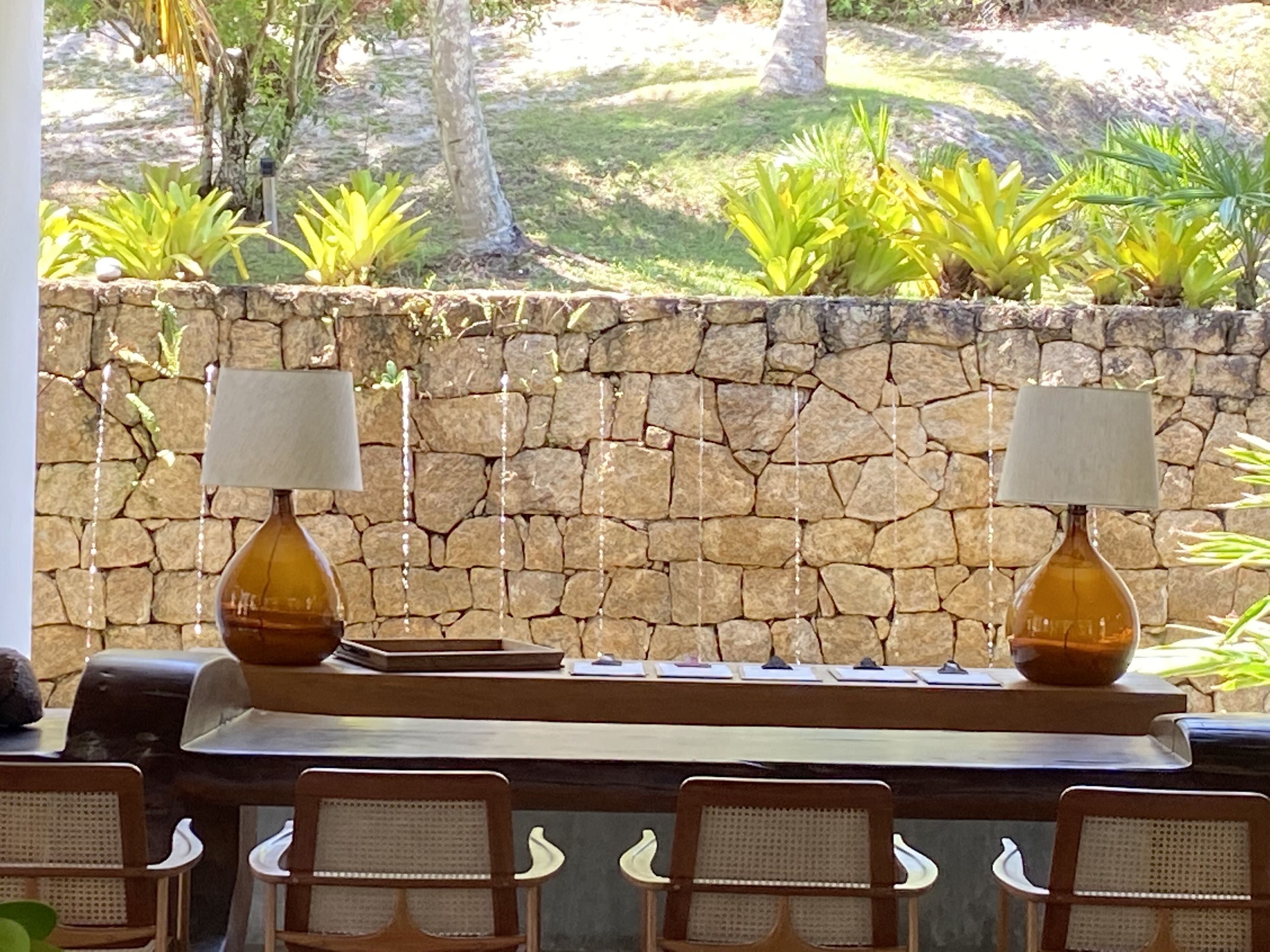 Un muro de piedra con una mesa y sillas al frente.