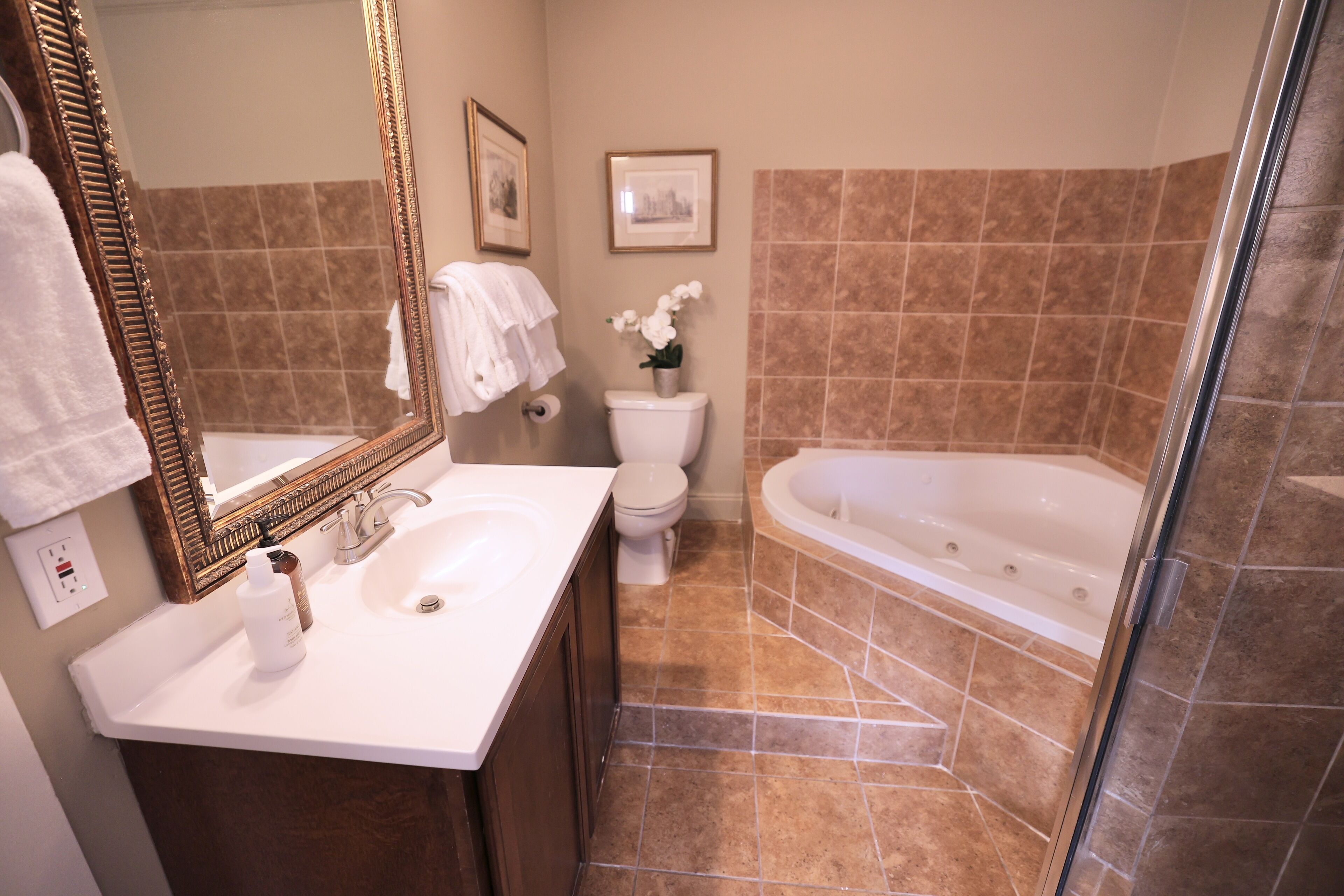 Een badkamer met een wit wastafel, toilet, bad en douche.