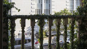 A building with arched windows and a stone balcony with ivy. - Foley House Inn (Savannah)