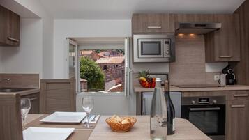 Een koelkast met diepvriezer, een microgolfoven, een oven, een kookplaat