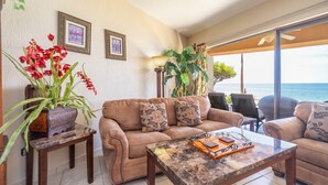 A cozy living room with a leather sofa, a coffee table, and a view of the ocean. - Sonoran Sun W-102 Sunset Strip Ground Floor Oceanfront Condo (Puerto Peñasco)