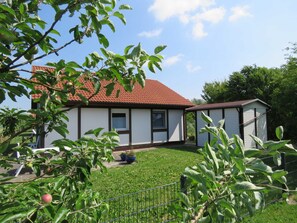 A house with a red-tiled roof, a white exterior, and a small attached garage.