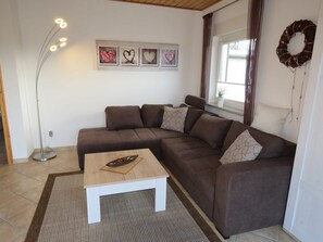 A modern living room with a sectional sofa, a coffee table, and a floor lamp.