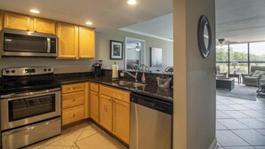 Una cocina moderna con armarios de madera, electrodomésticos de acero inoxidable y lavavajillas.