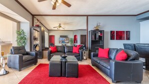 A modern living room with a red carpet, leather sofas, and a glass coffee table.