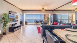 A spacious living area with a balcony, a dining table, and a sofa.