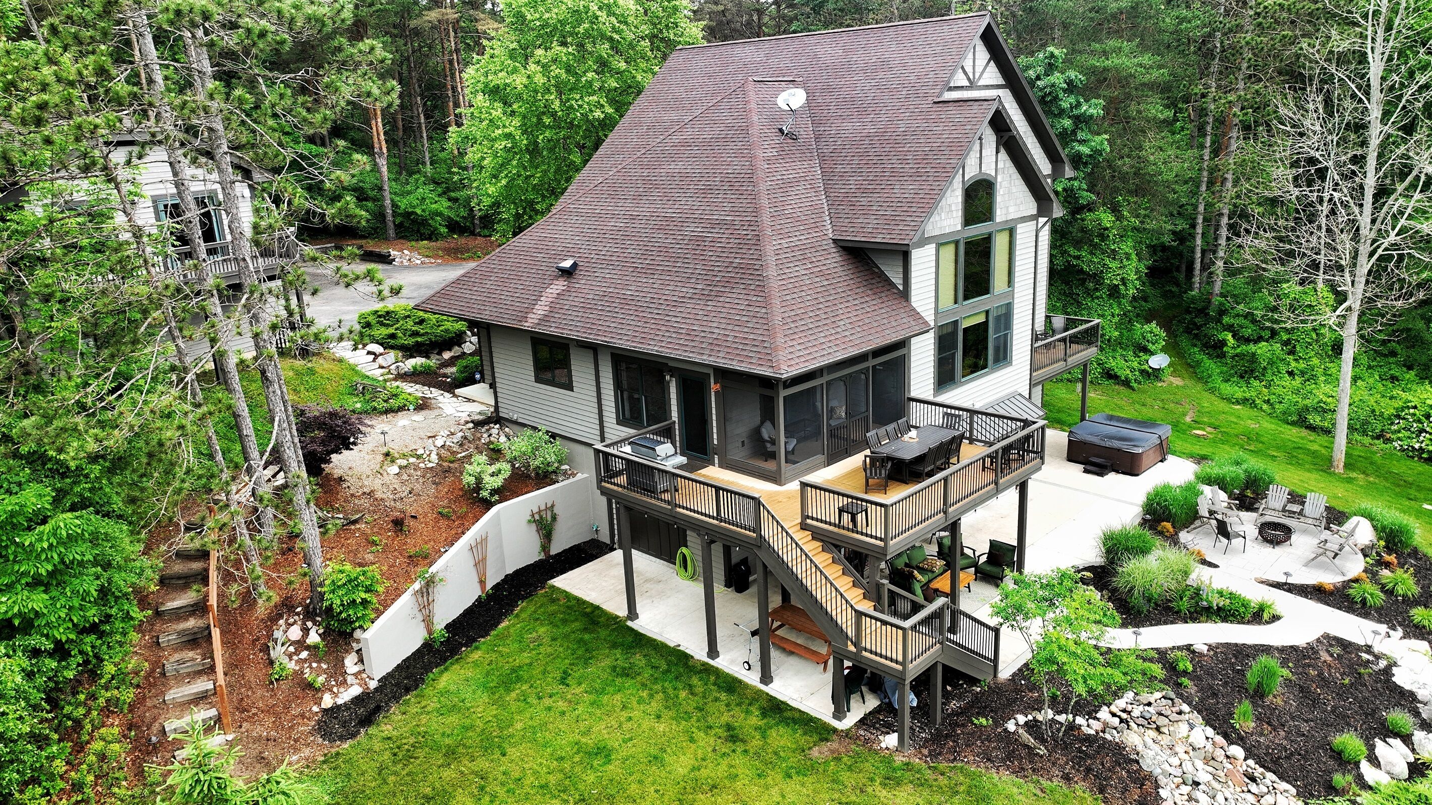 Une maison à deux étages dotée d’un balcon, d’une terrasse et d’un patio.