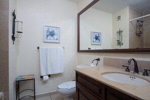 A bathroom with a sink, toilet, and a mirror. There are framed pictures on the wall and a towel hanging on the wall. - Sonoran Sun W-806 Chasing The Sun Great Oceanfront Condo (Puerto Peñasco)