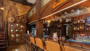 Eine Bar mit Holzeinrichtung, Wandgemälden und einer Auswahl an Spirituosen.