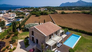 A two-story stone house with a swimming pool, surrounded by a well-maintained garden and fields. - Luxury villa for 10 with pool, gym, AC and wifi, only 150m to the sea  (Alcúdia)