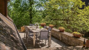 An outdoor dining area with a stone table and chairs, surrounded by potted plants and trees. - Pool Escape in Saint-Laurent (Saint-Laurent-la-Vallée)