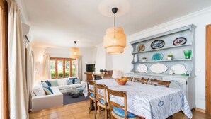 A dining area with a table set for four, surrounded by wooden chairs.