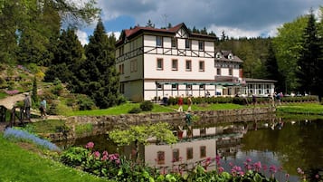 Un edificio tradicional con jardín y estanque.
