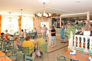 A restaurant with indoor seating, a bar area, and a variety of patrons.