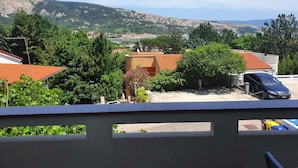 Un barrio residencial con casas, un coche y montañas al fondo.