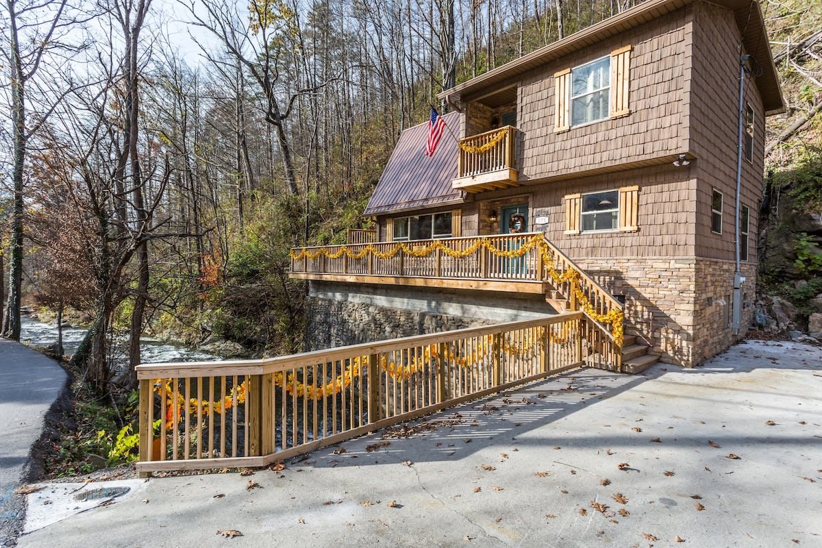 A two-story lodge with a balcony, a stone foundation, and a flag.