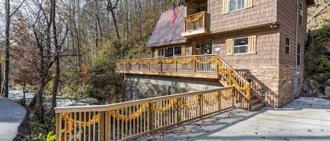 A two-story lodge with a balcony, a stone foundation, and a flag.