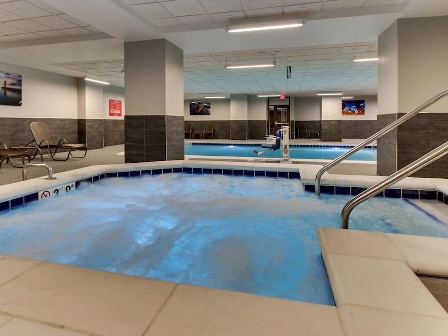 A swimming pool with a no diving sign, a chair area, and a stairway leading to the pool.