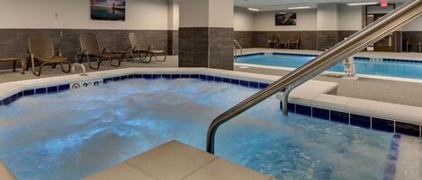 Uma área de spa com hidromassagem, espaço para sentar e piscina.