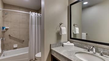 A bathroom with a bathtub, a shower, a sink, and a large mirror.