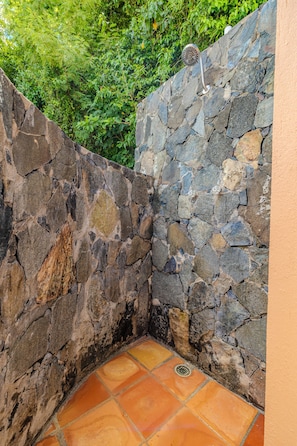 Experience a refreshing outdoor shower amidst lush greenery.