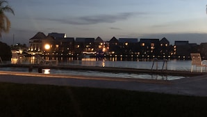 Un hotel frente al agua con varias edificaciones, una piscina y un muelle.