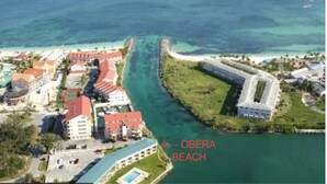 Vista aérea de una zona costera con un edificio destacado que dice "Obera Beach".