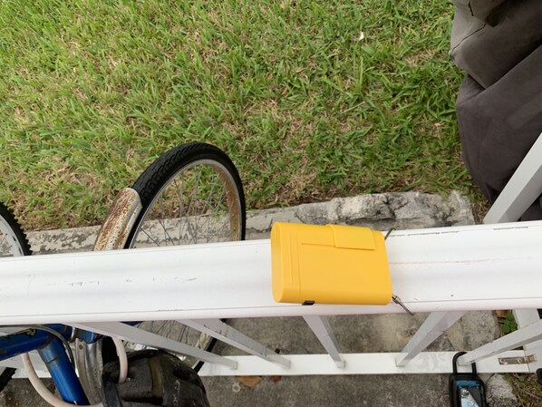 A bicycle with a yellow bag attached to the frame, parked on a concrete surface with grass in the background. - Luxurios bayview condo at Taino Beach I (Freeport)