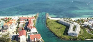 Vista aérea de una zona costera con un edificio destacado que dice "Obera Beach".