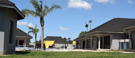Un barrio residencial con casas, piscina y palmeras.