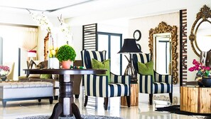 A modern living room with striped armchairs, a round coffee table, and a sofa.