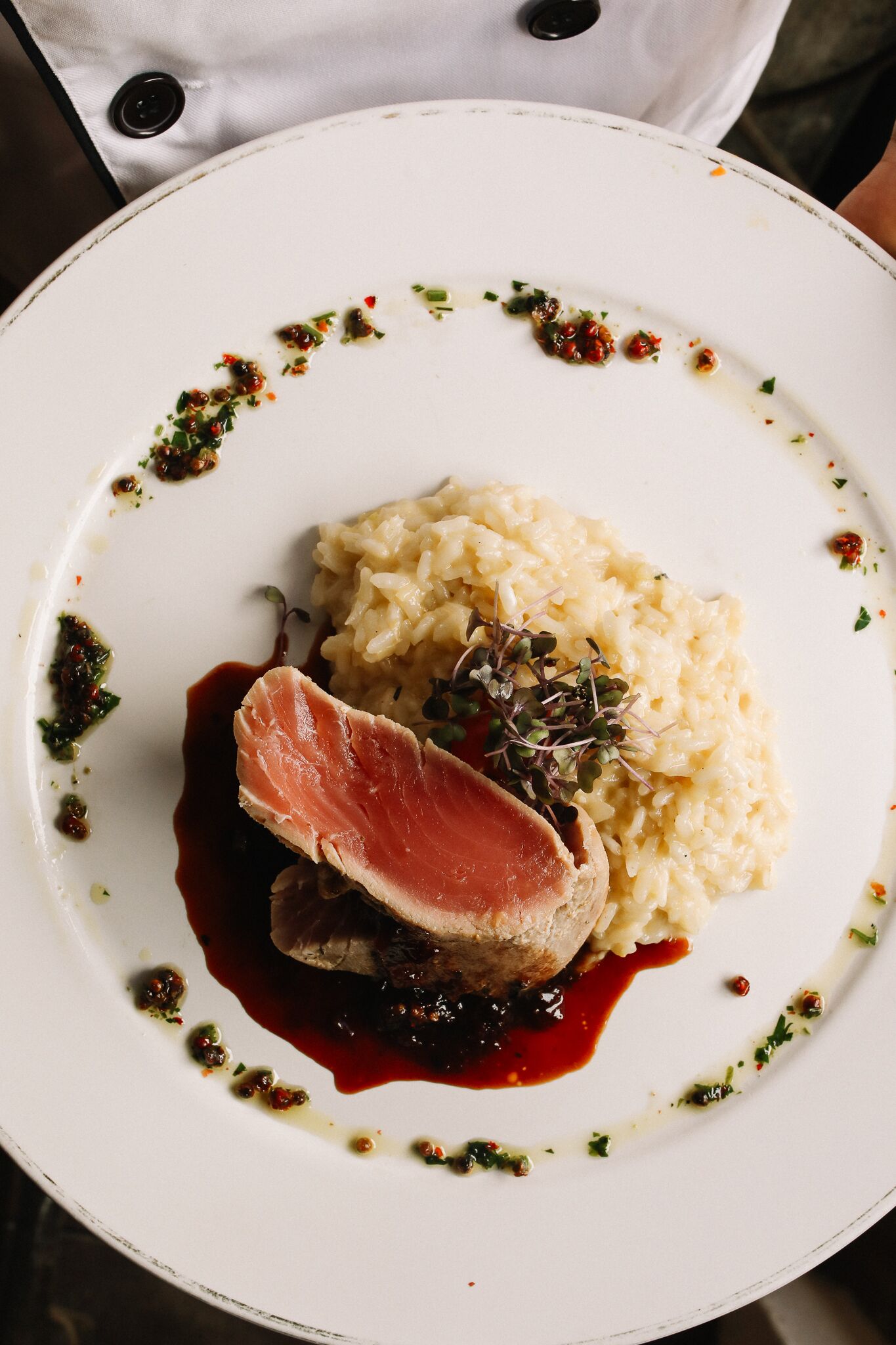 A plate of food with a slice of meat, mashed potatoes, and a sauce.