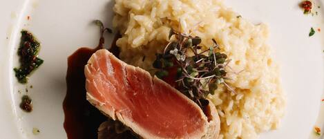 A plate of food with a slice of meat, mashed potatoes, and a sauce.