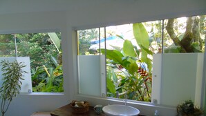 A bathroom with a large window, a white sink, and a potted plant. - Wonderful house with 5 suites in Barra do Sahy. (Praia Barra do Sahy)