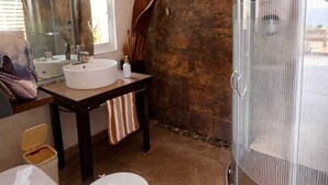 A bathroom with a shower, toilet, sink, and a large mirror. - Casa Qi Mazunte (Santa María Tonameca)
