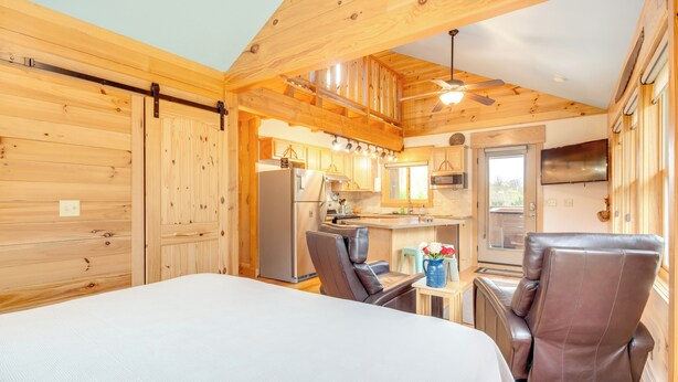 A wooden cabin interior with a dining area, kitchen, and a bed. - Peaceful Cabin Getaway, 15 minutes from Asheville (Fletcher)