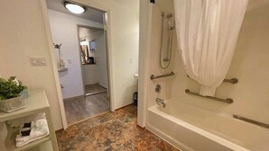 Ein Badezimmer mit Badewanne, Dusche und Fliesenboden.