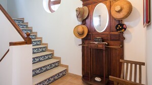 A staircase with patterned steps, a wooden cabinet with hats, and a mirror. - Ross Orange Apartment, Pool, Wifi (Faro)