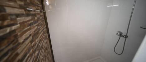A shower with a wooden ceiling and tiled walls.