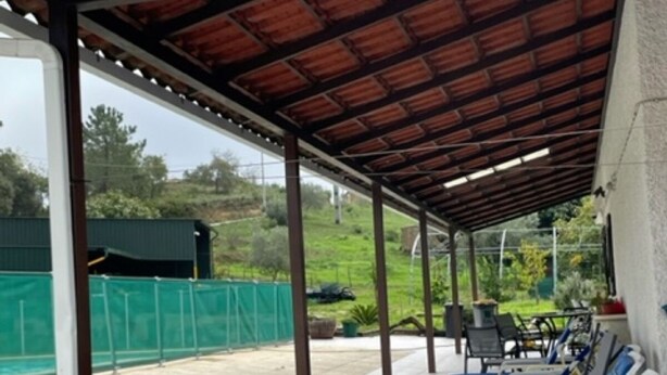 Un espace extérieur abrité, doté de chaises longues et d’une terrasse.